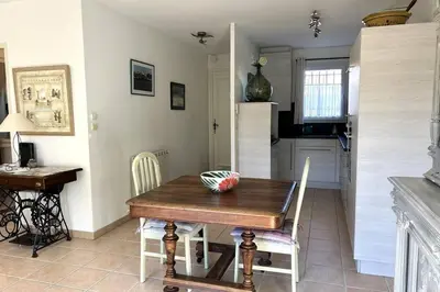 a kitchen and dining room with a wooden table and chairs at At Tinou's spacious quiet house with garden for 2 people in LʼIsle-sur-la-Sorgue