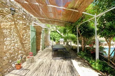 a wooden deck with a bench and a building at Le Mas Rose Thé in Robion en Luberon