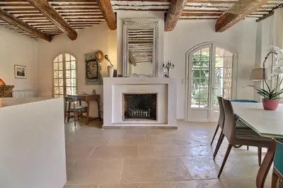 a living room with a fireplace and a table at Le Mas Rose Thé in Robion en Luberon