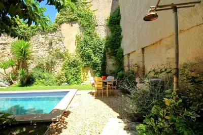 a house with a swimming pool next to a building at Le Mas Rose Thé in Robion en Luberon