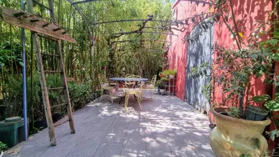 a patio with a table and chairs in a greenhouse at La Verrière des Songes in Robion en Luberon