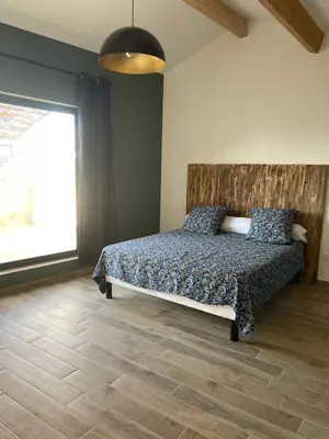 a bedroom with a bed and a large window at Maison du soleil in Caumont-sur-Durance