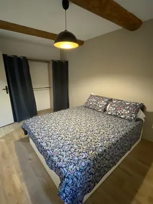 a bedroom with a bed with a comforter on it at Maison du soleil in Caumont-sur-Durance