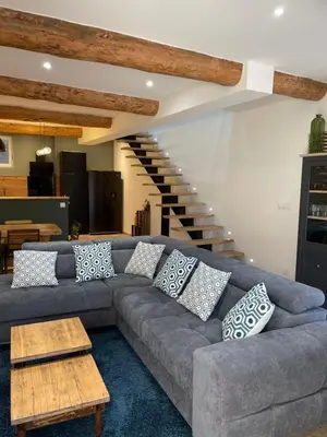 a living room with a gray couch with pillows on it at Maison du soleil in Caumont-sur-Durance