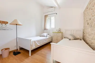 a white bedroom with two beds and a lamp at Mas de 190m2 Climatisé avec Piscine et Cuisine d'été - 10 pers in La Fare-les-Oliviers