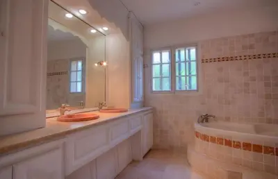 a bathroom with two sinks and a tub and a mirror at Villa Martine, authentic family home in Rognes