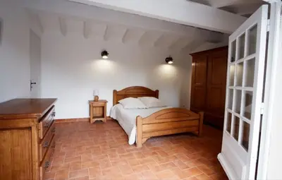 a bedroom with a bed and a wooden dresser at Villa Martine, authentic family home in Rognes