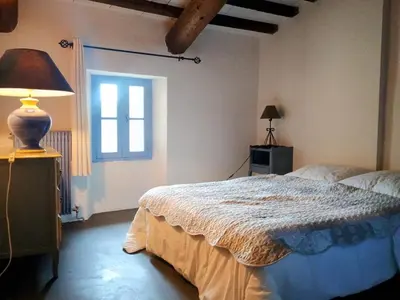a bedroom with a bed with a lamp and a window at Gîte Sorgue - Exceptionnel 125 m2 Piscine Parking Jardin in Saumane-de-Vaucluse
