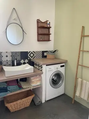 a bathroom with a washing machine and a mirror at 15 rue des pierres seches in Ferrassières