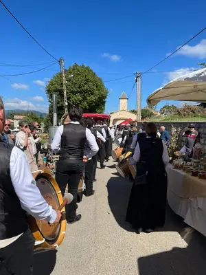 a group of people walking through a market at 15 rue des pierres seches in Ferrassières