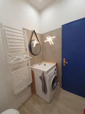 a bathroom with a washing machine and a sink at Appartement atypique dans un ancien couvent in LʼIsle-sur-la-Sorgue