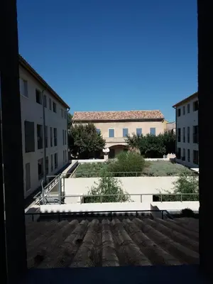 a view of a courtyard with two buildings at Appartement atypique dans un ancien couvent in LʼIsle-sur-la-Sorgue