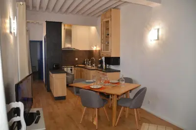 a kitchen with a table and chairs in a room at Appartement atypique dans un ancien couvent in LʼIsle-sur-la-Sorgue