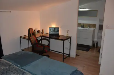 a bedroom with a desk with a laptop computer on it at Maison en coeur de ville in LʼIsle-sur-la-Sorgue
