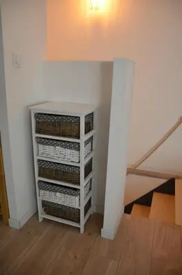 a white book shelf in a room with a staircase at Maison en coeur de ville in LʼIsle-sur-la-Sorgue