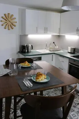a kitchen with a table with two plates of food on it at Appartement Centre Historique in LʼIsle-sur-la-Sorgue