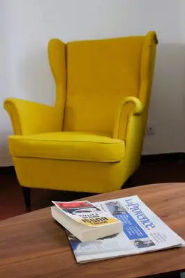 a yellow chair sitting on top of a table with a magazine at Appartement Centre Historique in LʼIsle-sur-la-Sorgue