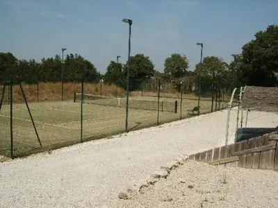 a tennis court with a net in a field at Pavillondulantana in Les Taillades