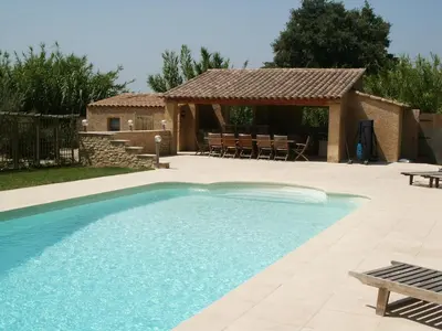 a swimming pool with a patio and a house at Pavillondulantana in Les Taillades