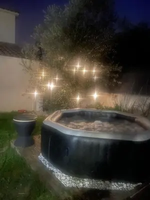 a bath tub in a yard at night at Villa entière piscine jacuzzi venelles in Venelles