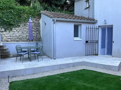 a patio with a table and chairs next to a building at Le petit bastidon gîte à Oppède avec piscine in Oppède