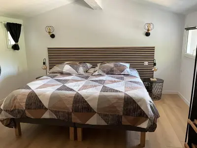 a bedroom with a bed with a quilt on it at Le petit bastidon gîte à Oppède avec piscine in Oppède