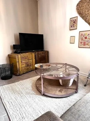 a living room with a glass table and a tv at Élégant T2 proche gare et centre in Miramas