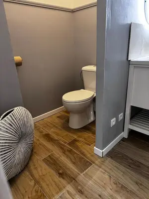 a bathroom with a toilet and a wooden floor at Élégant T2 proche gare et centre in Miramas