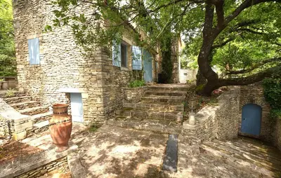 a stone building with stairs leading to a tree at Awesome Home In Goult With Wifi in Goult