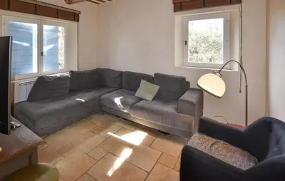 a living room with a couch and two windows at Awesome Home In Goult With Wifi in Goult