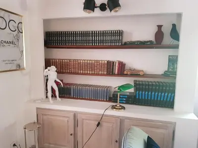 a shelf with books and a statue on top of a cabinet at Magnifique Villa Provençale in Rognes