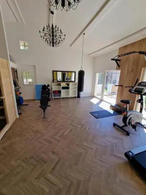 a room with a gym with exercise equipment and a chandelier at Magnifique Villa Provençale in Rognes
