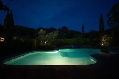a swimming pool at night in a garden at Magnifique Villa Provençale in Rognes