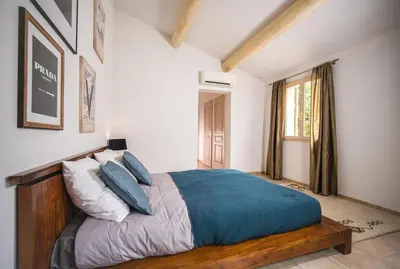 a bedroom with a large bed with blue pillows at Magnifique Villa Provençale in Rognes