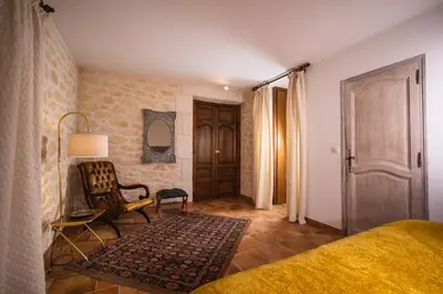 a bedroom with a bed and a chair and a door at Magnifique Villa Provençale in Rognes