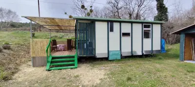 a small white and green house with a roof at Chalets dans le Luberon in Viens