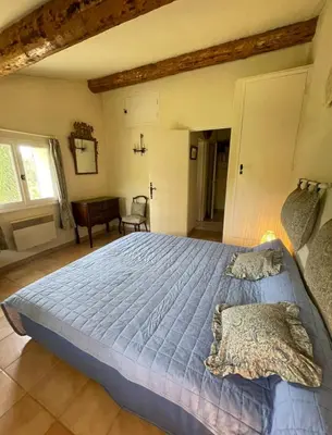 a bedroom with a large bed with a blue comforter at Domaine au cœur du Colorado Provençal in Gignac