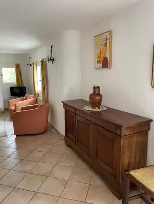 a living room with a table and a couch at Domaine au cœur du Colorado Provençal in Gignac