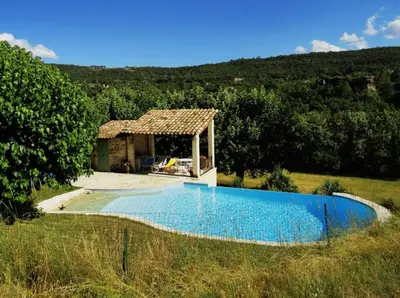 a pool in a field with a gazebo at Domaine au cœur du Colorado Provençal in Gignac