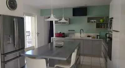 a kitchen with a table and some chairs in it at Manava in Cheval-Blanc