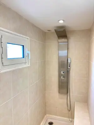 a bathroom with a shower with a television on the wall at Paul Cézanne garden apartment with air conditioning in Aix-en-Provence
