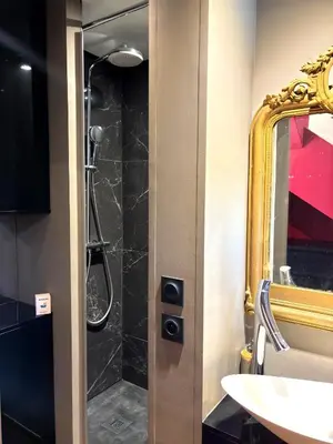 a bathroom with a shower with a sink and a mirror at Paul Cézanne garden apartment with air conditioning in Aix-en-Provence