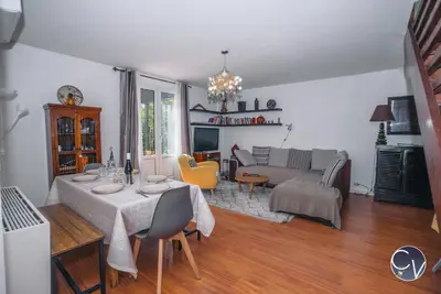 a living room with a table and a couch at Maison entière à 300m du centre in LʼIsle-sur-la-Sorgue