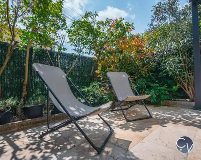 a pair of chairs sitting on a patio at Maison entière à 300m du centre in LʼIsle-sur-la-Sorgue