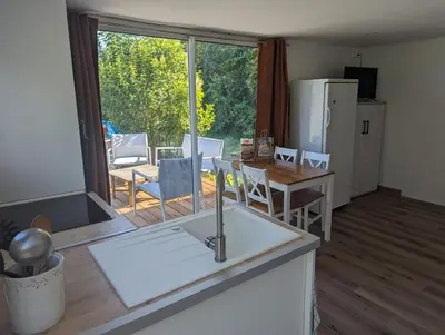a kitchen with a sink and a table with chairs at Cottage with Natural Pool in LʼIsle-sur-la-Sorgue