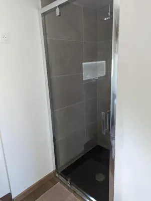 a shower with a glass door in a bathroom at Cottage with Natural Pool in LʼIsle-sur-la-Sorgue