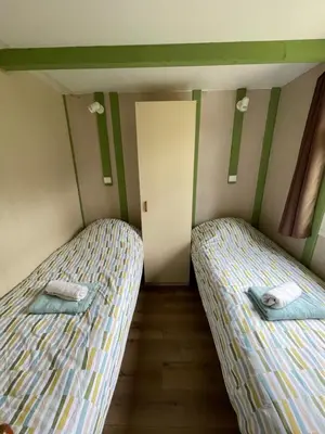 two beds in a small room with a door at Cottage with Natural Pool in LʼIsle-sur-la-Sorgue