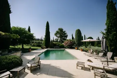 a swimming pool in a yard with chairs and an umbrella at The Aviary - Pernes-les-Fontaines in Pernes-les-Fontaines