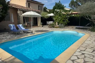 a swimming pool in a yard with a house at La Maison Rose in LʼIsle-sur-la-Sorgue