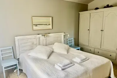 a bedroom with a white bed with two towels on it at La Maison Rose in LʼIsle-sur-la-Sorgue